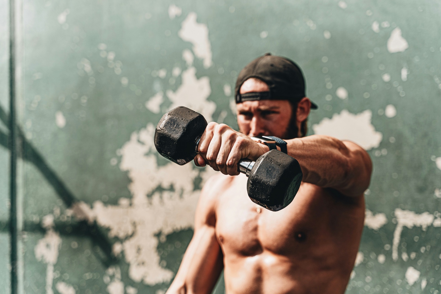 Athlete training with a dumbbell and wearing an Apple Watch